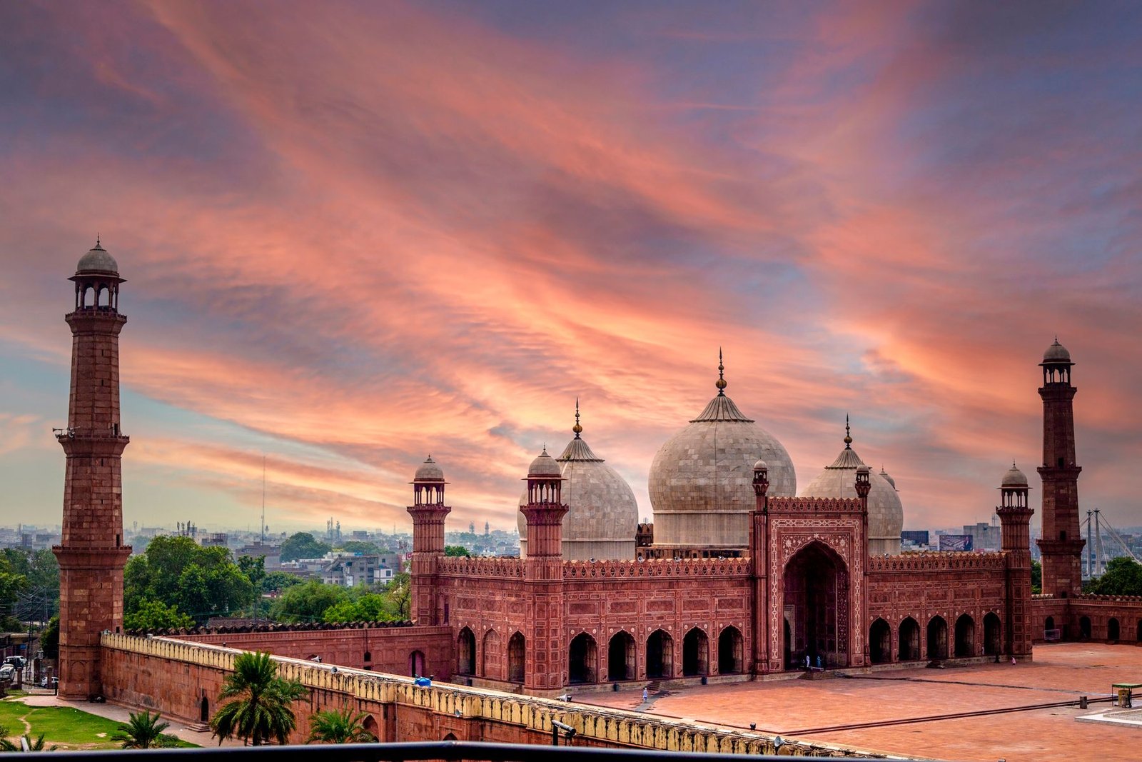Badshahi Mosque in Lahore at sunset with its red sandstone facade, white marble domes and four minarets